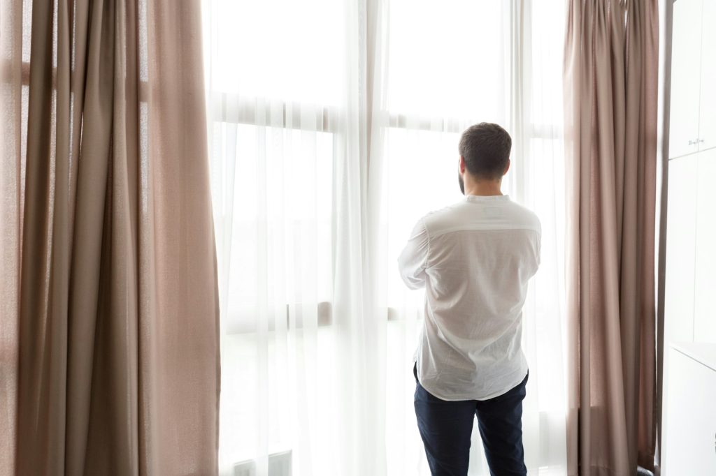 Thoughtful man standing by window